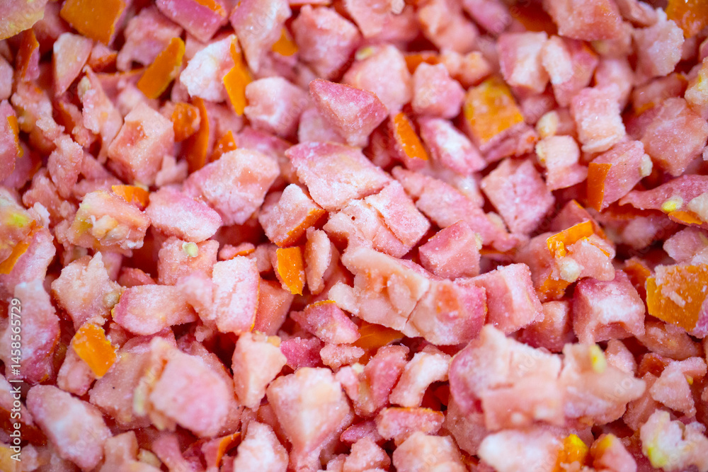 Close-up of shock-frozen diced red tomatoes with a thin ice coating. Are prepared for retail packaging to ensure extended shelf life in supermarkets and maintain perishable harvest quality.