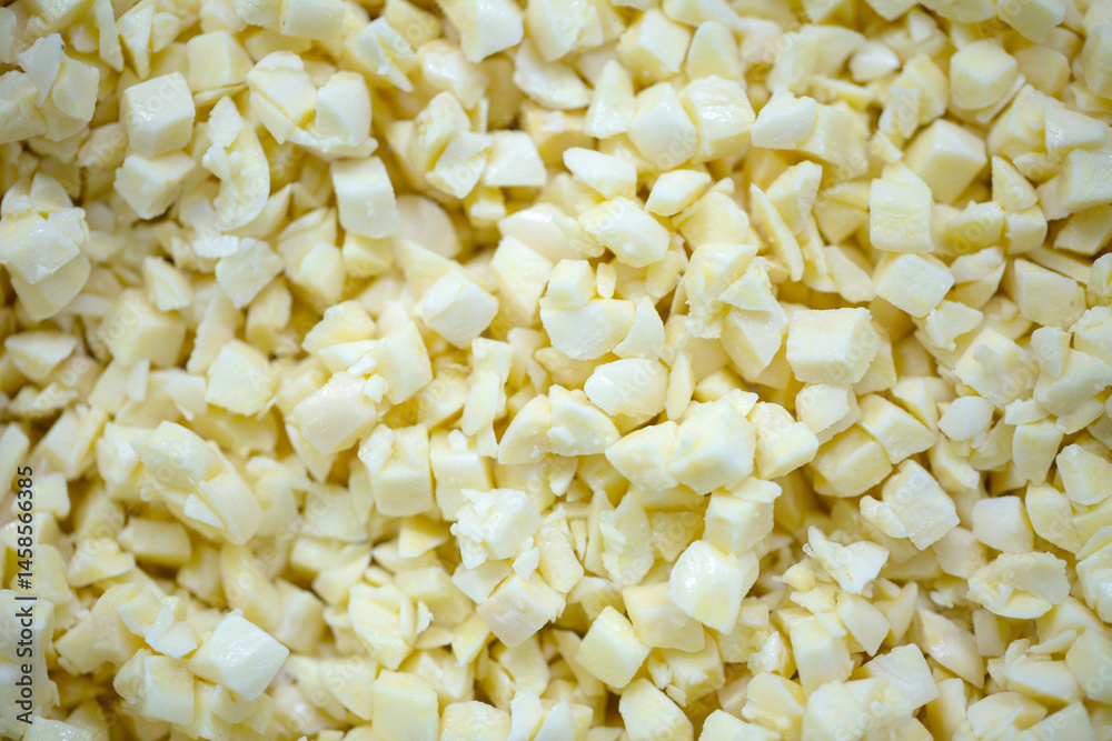 Close-up of shock-frozen chopped garlic pieces with a thin ice coating. Are prepared for retail packaging to ensure extended shelf life in supermarkets and maintain perishable harvest quality.