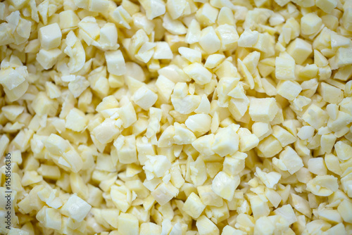 Obraz na płótnie Close-up of shock-frozen chopped garlic pieces with a thin ice coating. Are prepared for retail packaging to ensure extended shelf life in supermarkets and maintain perishable harvest quality. w salonie