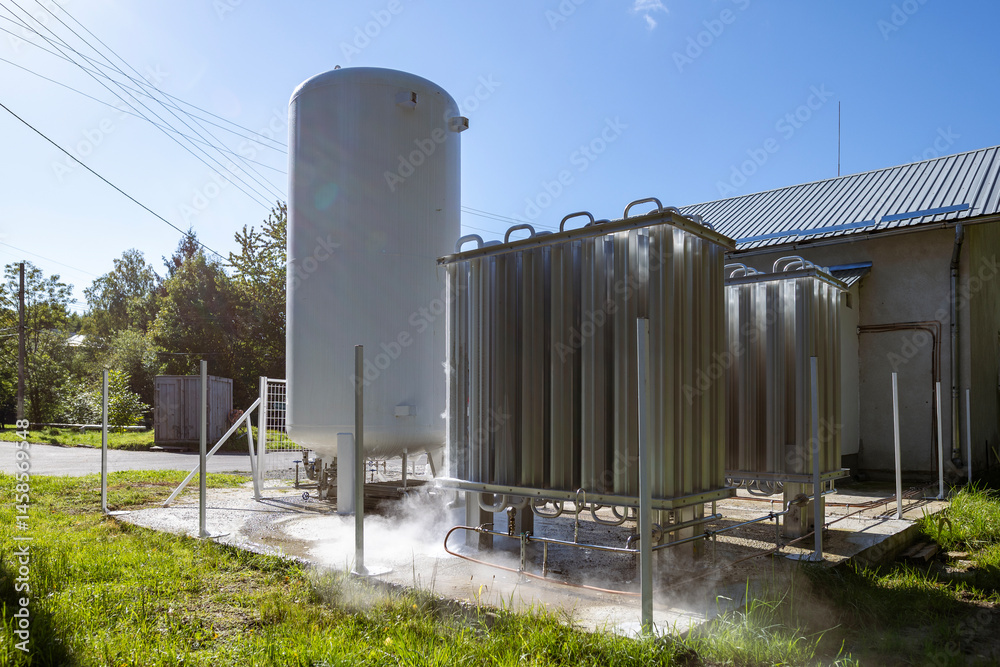 Fototapeta premium An oxygen station that produces and supplies medical oxygen to a hospital. The station includes radiators and a large white cylinder containing liquefied oxygen for distribution.