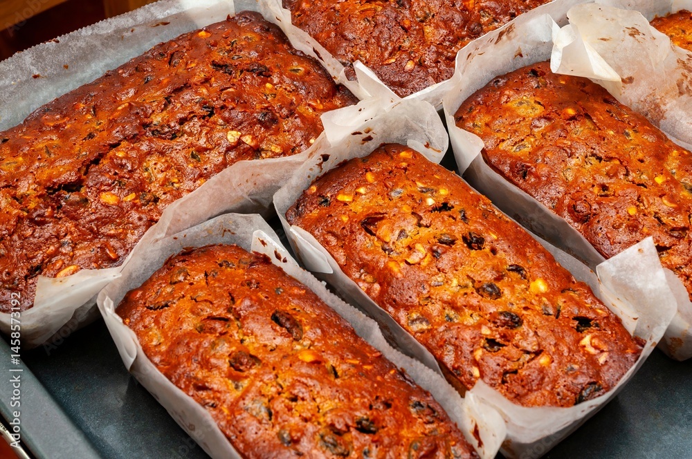 Freshly baked fruit and nut bread loaves, golden and inviting, ready to be enjoyed for a treat.