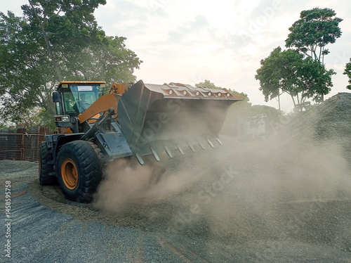 Loader operating on a construction site, raising dust