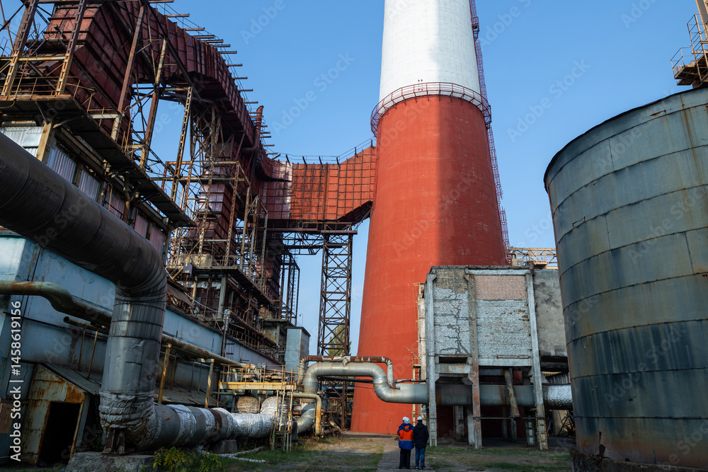 A massive gas exhaust system at a high-capacity thermal power plant. Towering red-and-white chimneys exceed 150 meters in height, facilitating emissions management and industrial air circulation.