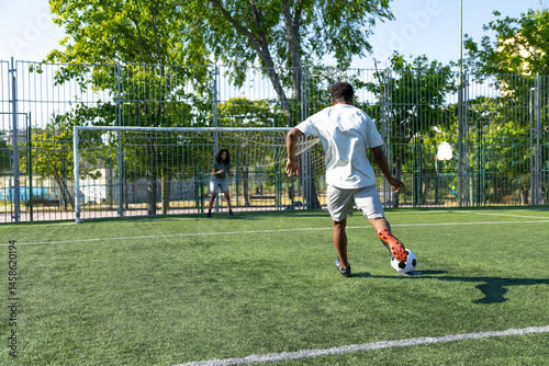 Soccer player kicking ball into goal during penalty kick