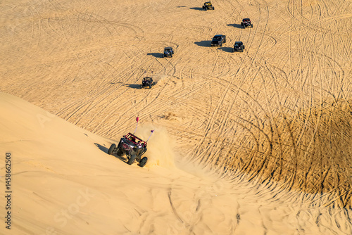 A buggy is racing at high speed over a sand dune in desert. Arab entertainment in the desert. 4x4, travel in off-road vehicles. off road sport
