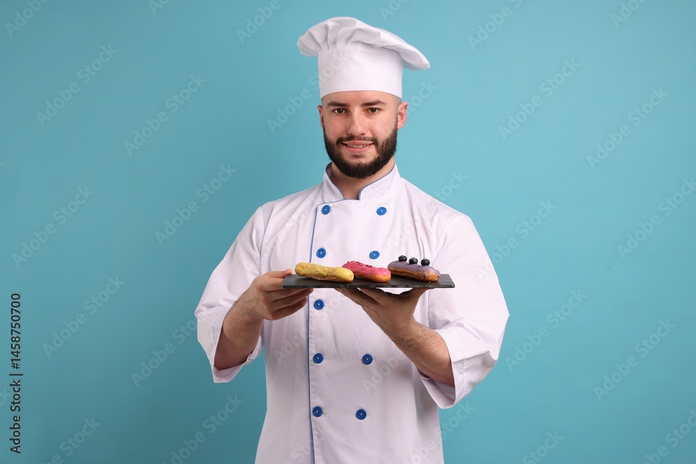 Happy confectioner in uniform holding delicious eclairs on light blue background Happy confectioner in uniform holding delicious eclairs on light blue background