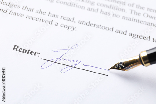 Fountain pen leaving signature on contract, closeup