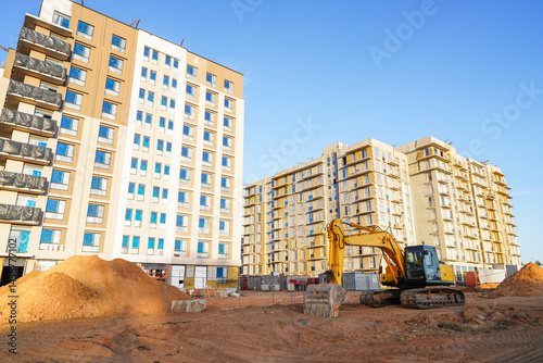 Wallpaper Mural Excavator on earthworks on Construction site. Building under construction. Excavator on groundwork. Backhoe on earthmoving. Earthmover. Buildings construction and renovation.. Torontodigital.ca