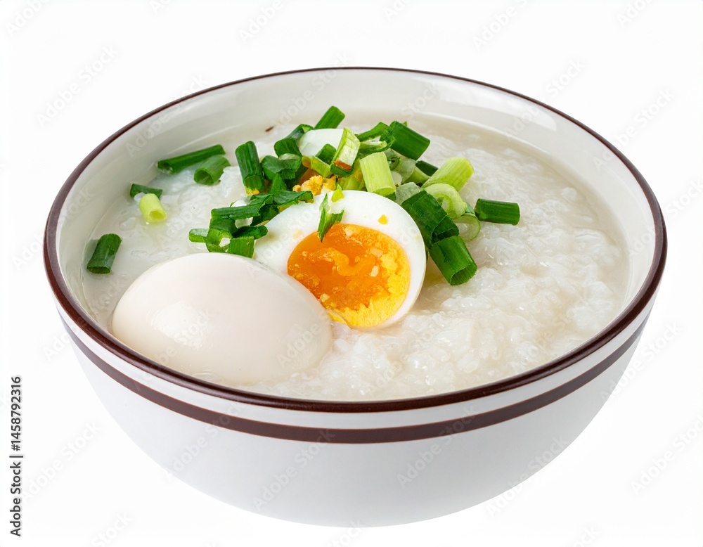 A bowl of comforting rice porridge, garnished with sliced eggs and green onions, is a hearty, satisfying meal A bowl of comforting rice porridge, garnished with sliced eggs and green onions, is a hearty, satisfying meal