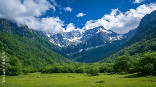Majestic snow-capped mountains rise above a vibrant green valley, dotted with lush trees and a tranquil meadow under a bright blue sky. : Generative AI