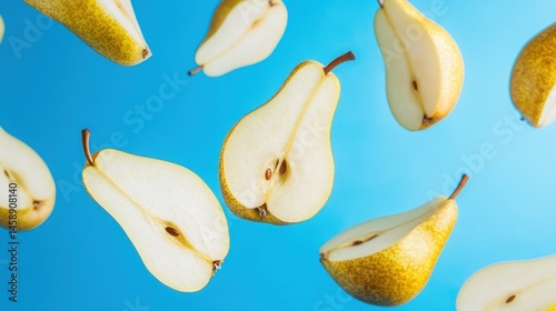 Fresh pear halves in mid-air against a vibrant blue background