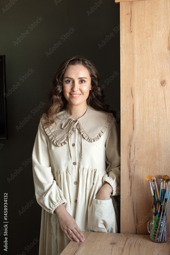 Smiling Artist Standing by Easel in a Bright Studio