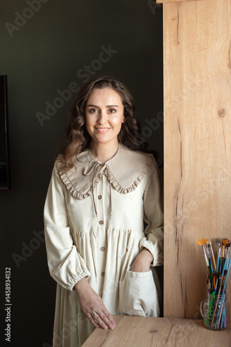 Obraz na płótnie Smiling Artist Standing by Easel in a Bright Studio w salonie