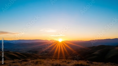 Majestic sunset over rolling hills and mountains, showcasing vibrant orange and blue hues, with sun rays illuminating the landscape. : Generative AI