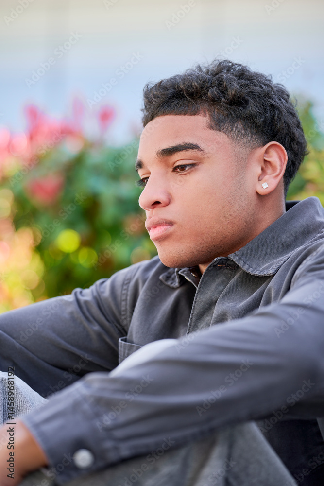 young Dominican teenager with a fashionable outfit sits alone in an outdoor park with a concerned expression, lost in thought. A natural scene reflecting emotional depth and adolescent concerns young Dominican teenager with a fashionable outfit sits alone in an outdoor park with a concerned expression, lost in thought. A natural scene reflecting emotional depth and adolescent concerns