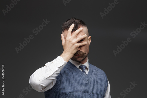 guy in office clothes expressing emotions on dark background. concept headache, anger, disappointment.