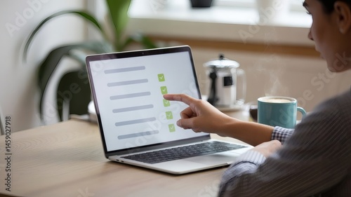 A person completes an online form using a laptop, as shown from behind. Green checkmarks on the screen indicate successful item completion.