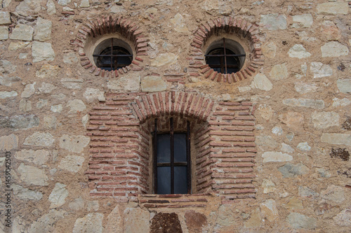 Pareidolia. Two circular windows and an elongated window, which looks like a face in a stone wall in the town of Pedraza, province of Segovia. Spain