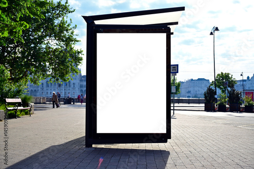 Fototapeta Naklejka Na Ścianę i Meble -  bus shelter at a busstop. blank billboard ad display. empty white lightbox sign. glass and aluminum structure. city transit station. urban street setting. white outdoor advertising mockup.