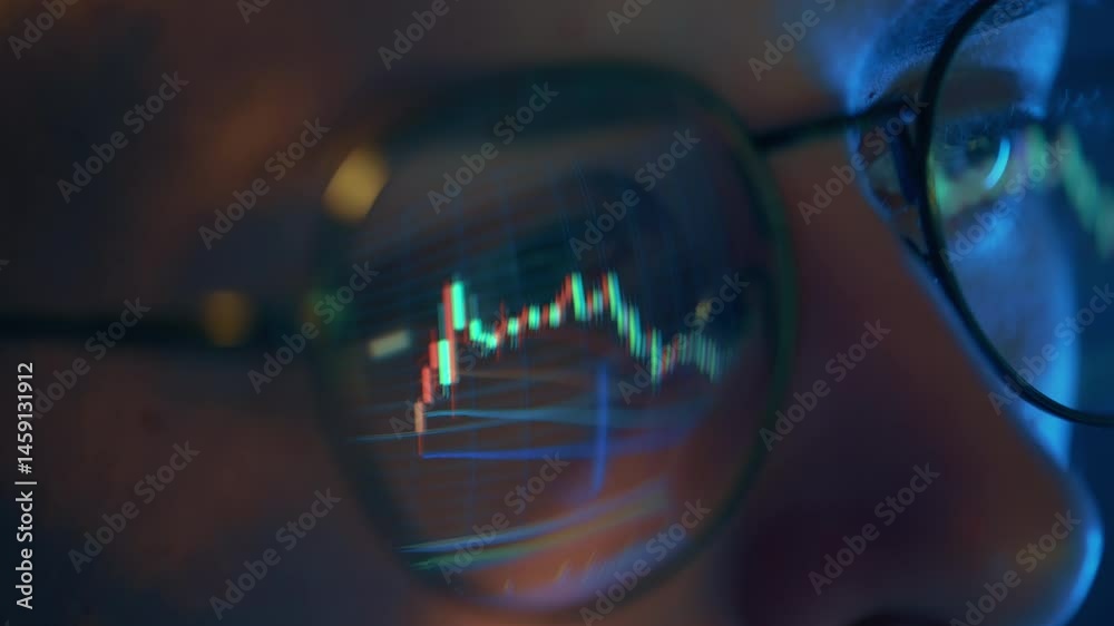 Trader wearing glasses is working on laptop computer. Screen with stock market charts and Bitcoin BTC or Ethereum ETH data analysis reflection. Broker trading online. Altcoins crypto currency trading