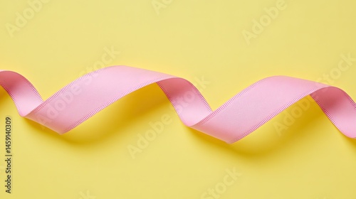 Obraz na płótnie Pastel pink ribbon on a yellow background w salonie