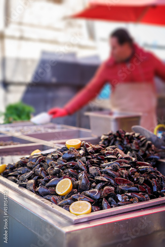 Black mussels with lemon at one of the stalls at the fish market.