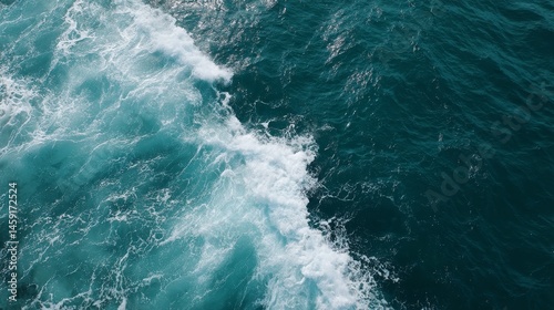 Aerial shot showcases the rolling ocean surface featuring rich turquoise hues and rhythmic waves, creating a serene and tranquil atmosphere