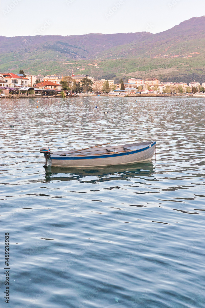 Naklejka premium Lake Ohrid, North Macedonia, April 13 2024. Mountain range and peninsula in distance. Ohrid Lake, Macedonia, Europe. The clear mesmerizing waters of lake Ohrid with a beautiful view. 