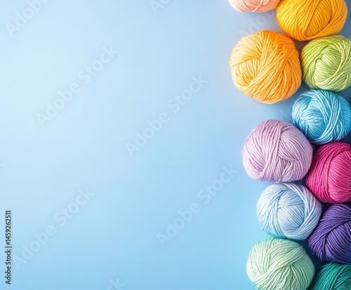 Knitting with rainbow yarn on a blue background, top view, with space for copying