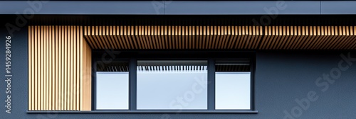 Modern facade with a wood accent.  Dark gray exterior wall with a horizontal wooden slatted trim above a window