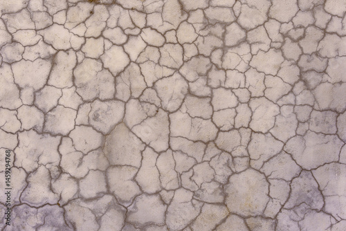 Cracks in the plaster covering the old gray wall. Abstract construction background.