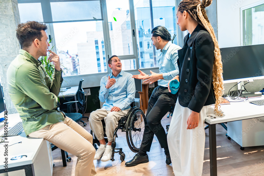 Diverse business team discussing in modern office with disabled colleague in wheelchair