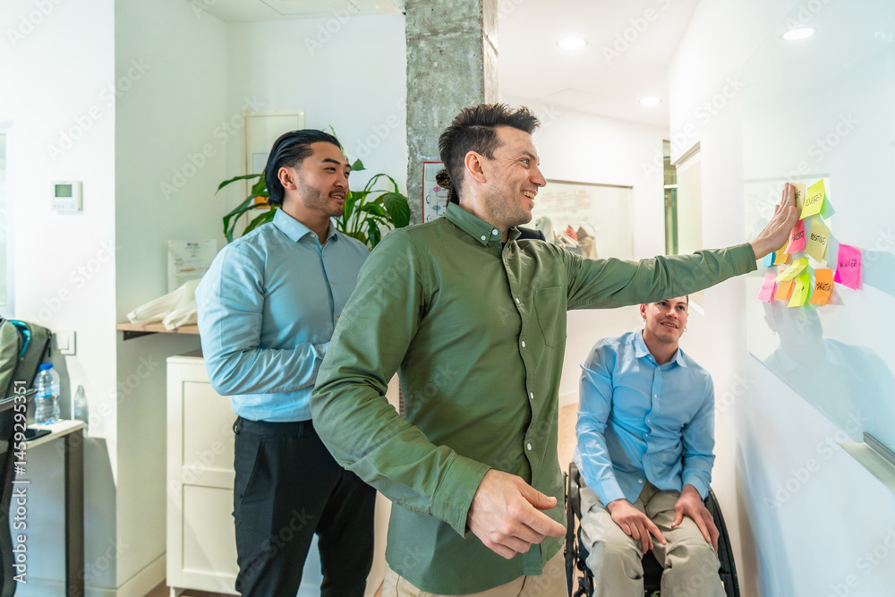 Business team analyzing notes on whiteboard during meeting