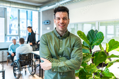 Obraz na płótnie Confident businessman smiling with arms crossed in accessible office environment w salonie