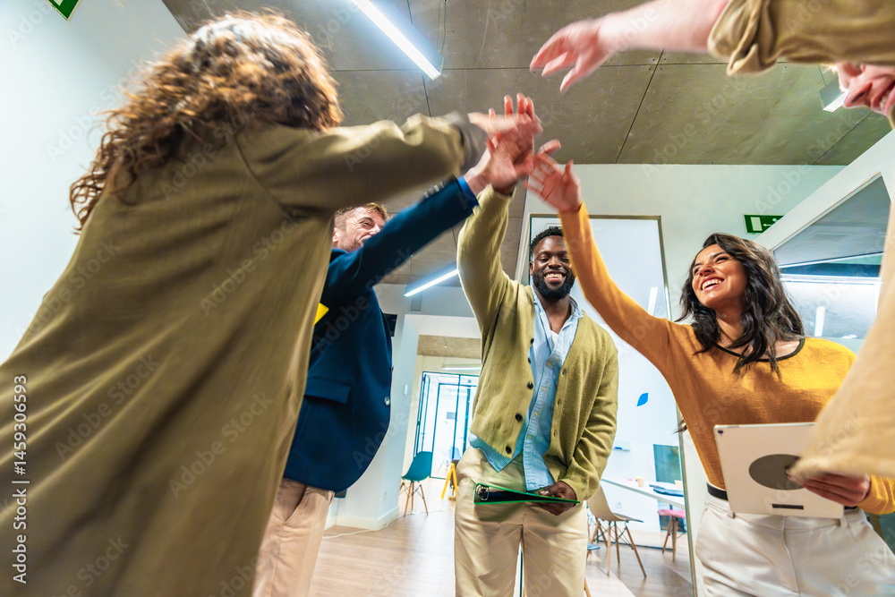 Business team celebrating success joining hands in modern office