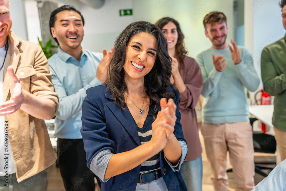Happy business team clapping and celebrating success in office meeting