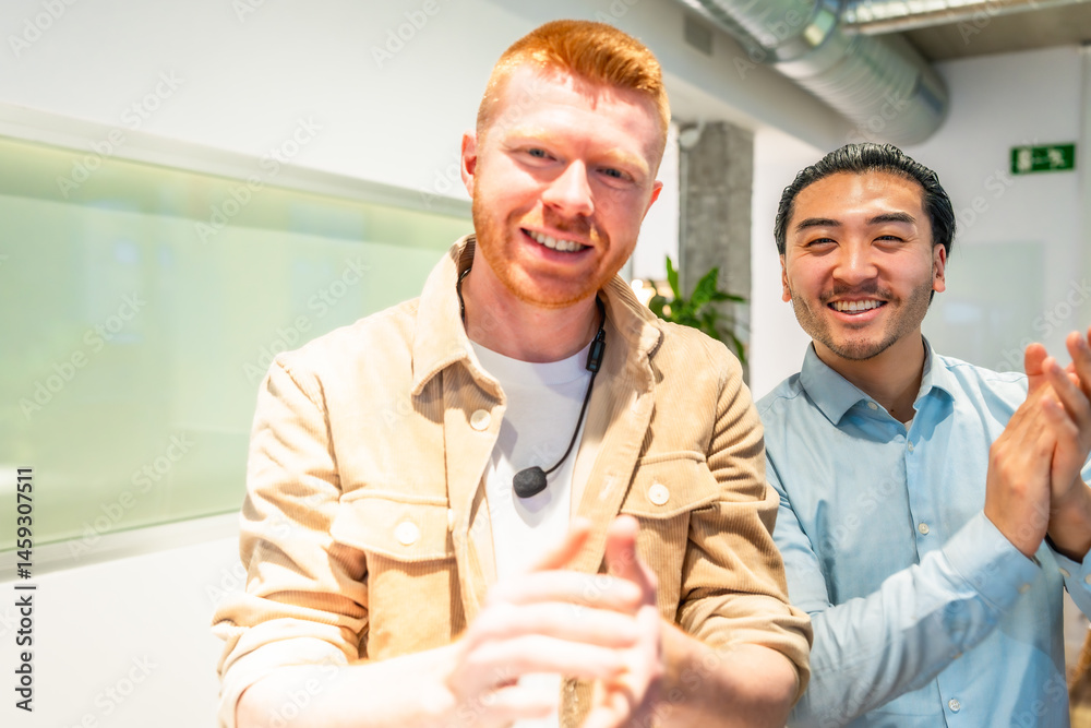 Two happy businessmen clapping and smiling in modern office