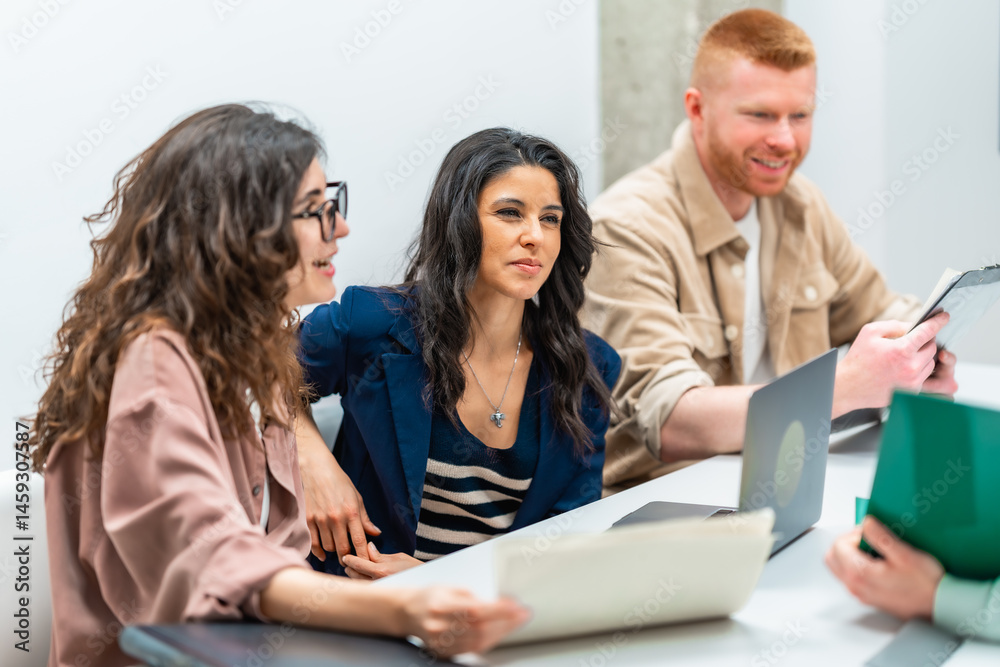 Business people collaborating during meeting using documents and devices