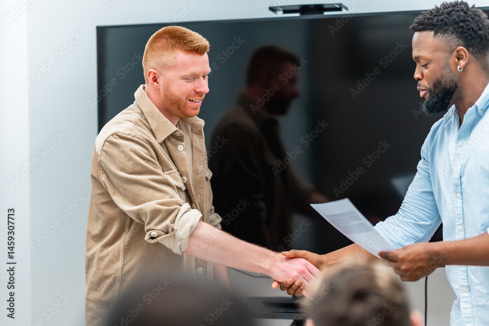 Businessmen shaking hands after signing contract in meeting room