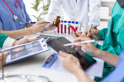 Medical team discussing diagnosis and treatment using x-ray and blood test results. Doctors is analyzing x-ray results and blood test sample to determine the best course of treatment for patient.