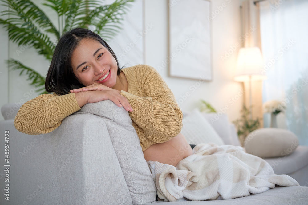 Happy pregnant woman relaxing on a cozy sofa, smiling warmly in a bright and peaceful living room. Happy pregnant woman relaxing on a cozy sofa, smiling warmly in a bright and peaceful living room.