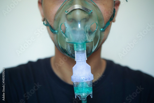 Close up Young man using nebulizer for asthma and respiratory diseases at home