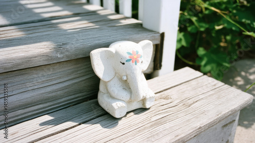 Serene elephant figurine on sunlit wooden steps, invoking Ganesha Chaturthi calmness, rustic charm with a splash of whimsy