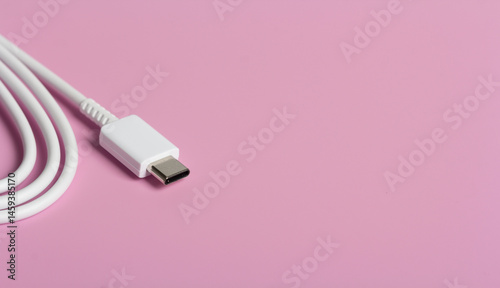 Obraz na płótnie Coiled USB-C data and charging cable on light pink surface with copy space w salonie