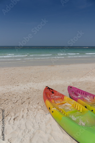 Colorfull canoes for tourism on the white sand beach.