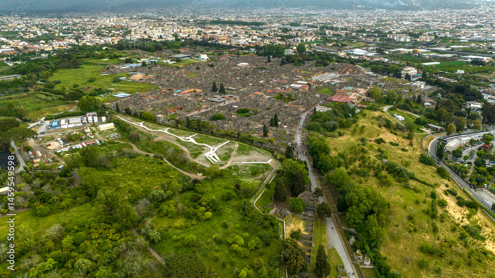 Aerial view of the ruins and remains in the archaeological park of Pompeii, located in the province of Naples, Campania, Italy. It was an ancient Roman town. In background there is the modern city.