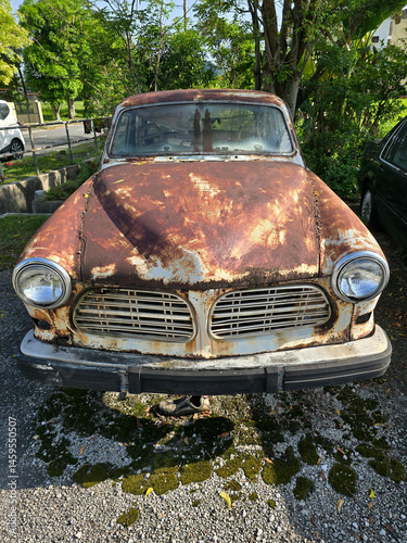 Front View of a Rusty Vintage Car Parked Outdoors
