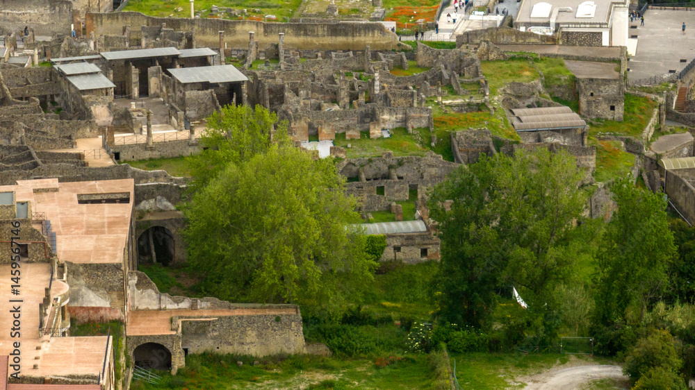 Aerial view of the ruins of houses and buildings of the ancient Roman city of Pompeii. The archaeological park is located in the province of Naples, Campania, Italy.