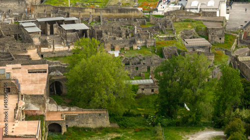 Aerial view of the ruins of houses and buildings of the ancient Roman city of Pompeii. The archaeological park is located in the province of Naples, Campania, Italy.

