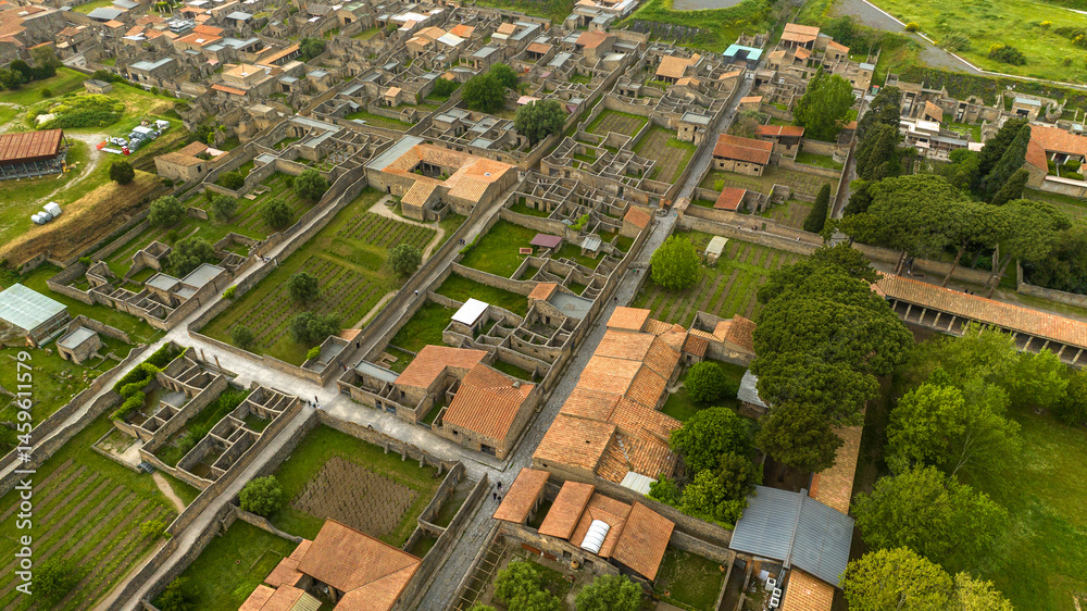 Aerial view of the ruins of houses and buildings of the ancient Roman city of Pompeii. The archaeological park is located in the province of Naples, Campania, Italy.
